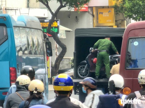 Đến hơn 12h trưa cùng ngày, lực lượng chức năng vẫn đang phong tỏa đoạn đường phía quán bar. Trong ảnh: lực lượng chức năng đưa một chiếc xe máy lên xe của công an lúc 12h7' - Ảnh: NGỌC KHẢI Đến hơn 12h trưa cùng ngày, lực lượng chức năng vẫn đang phong tỏa đoạn đường phía quán bar. Trong ảnh: lực lượng chức năng đưa một chiếc xe máy lên xe của công an lúc 12h7' - Ảnh: NGỌC KHẢI