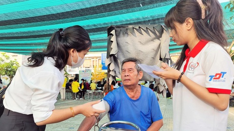 Sẻ chia hơi ấm Xuân tình nguyện- Ảnh 1. Chiến sĩ Xuân tình nguyện hỗ trợ thăm khám sức khỏe cho ông Nguyễn Văn Cường (69 tuổi) ở huyện Nhà Bè (TP.HCM) - Ảnh: C.TRIỆU