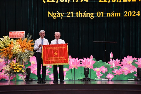 Hội Bảo trợ bệnh nhân nghèo TP.HCM đạt kỷ lục ca mổ mắt và tim miễn phí- Ảnh 1. Ông Võ Văn Hoan - phó chủ tịch UBND TP.HCM - (bên trái) trao tặng cờ truyền thống UBND TP cho Hội Bảo trợ bệnh nhân nghèo TP.HCM trong buổi lễ kỷ niệm 30 năm thành lập hội - Ảnh: X.M.