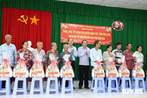 Lãnh đạo TP.HCM thăm, chúc Tết tại tỉnh Vĩnh Long- Ảnh 1. Phó bí thư thường trực Thành ủy TP.HCM Nguyễn Hồ Hải (ở giữa, bên trái) tặng quà Tết cho các hộ dân khó khăn huyện Mang Thít - Ảnh: CẨM NƯƠNG