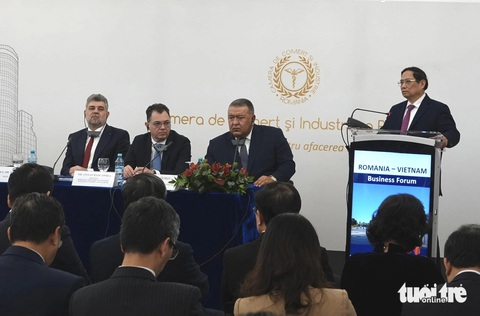 Romania muốn kết nối, hợp tác cảng với Việt Nam- Ảnh 1. Thủ tướng Romania Marcel Ciolacu (bìa trái) lắng nghe phát biểu của Thủ tướng Phạm Minh Chính tại Diễn đàn doanh nghiệp Việt Nam - Romania - Ảnh: QUỲNH TRUNG
