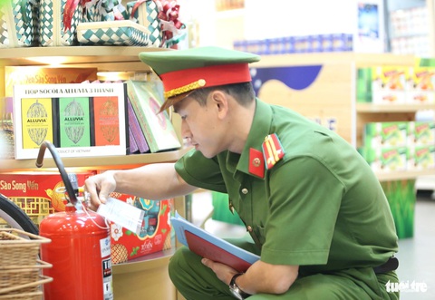 Chỉ 2 phút để xe cứu hỏa tiếp cận khi có máy bay bị cháy- Ảnh 5. Trung tá Lê Tấn Châu kiểm tra bình chữa cháy được đặt trong khu vực nhà chờ lên tàu bay - Ảnh: MINH HÒA