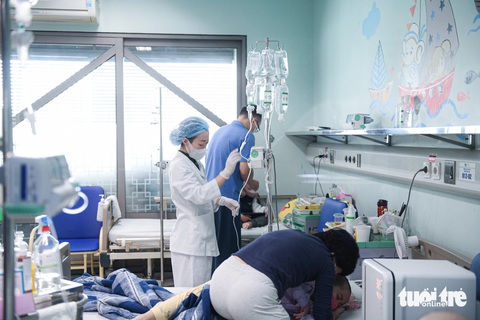 Tết này, bệnh viện cũng là nhà- Ảnh 1. Chị Minh (mẹ bé Hải Anh) ghì ôm chặt cô con gái nhỏ trong tay để con bớt sợ - Ảnh: NAM TRẦN