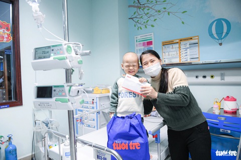 Tết này, bệnh viện cũng là nhà- Ảnh 3. Bé Hồng Quang vui vì được lì xì sớm - Ảnh: NAM TRẦN