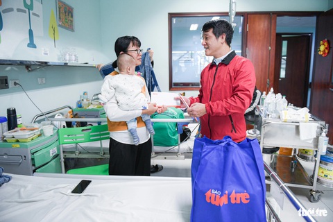 Nhà báo Nguyễn Đức Bình - phó trưởng văn phòng đại diện Báo Tuổi Trẻ tại Hà Nội - tặng quà cho gia đình bệnh nhi - Ảnh: NAM TRẦN Nhà báo Nguyễn Đức Bình - phó trưởng văn phòng đại diện báo Tuổi Trẻ tại Hà Nội - tặng quà cho gia đình bệnh nhi - Ảnh: NAM TRẦN