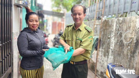 Trăn đất bò lên giường ngủ của một gia đình ở quận 12- Ảnh 2. Con trăn đất (đựng trong túi lưới) mà bà Tôn Nữ Thị Xí giao cho Chi cục Kiểm lâm TP.HCM - Ảnh: NGỌC KHẢI