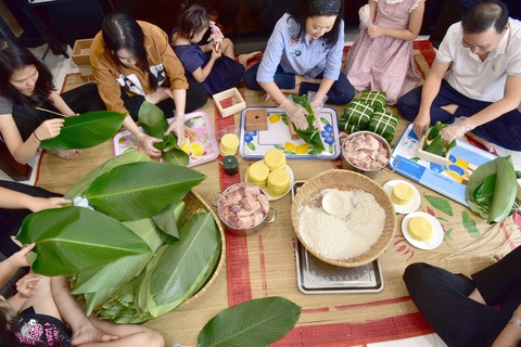 Đón Tết trút bỏ âu lo- Ảnh 1. Cả gia đình ở quận 7 (TP.HCM) cùng gói bánh chưng - Ảnh: T.T.D.