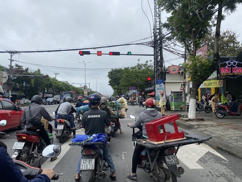 Chuyện lạ ở Đà Nẵng: Đèn đỏ được rẽ phải nhưng rẽ được hay không thì còn... hên xui!- Ảnh 4. Sau khi được cảnh sát giao thông yêu cầu nhường làn rẽ phải, người phụ nữ (ngoài cùng, bên phải) này luồn phần trước xe qua một bên để đối phó, 2/3 thân xe vẫn nằm bên làn rẽ - Ảnh: B.D.
