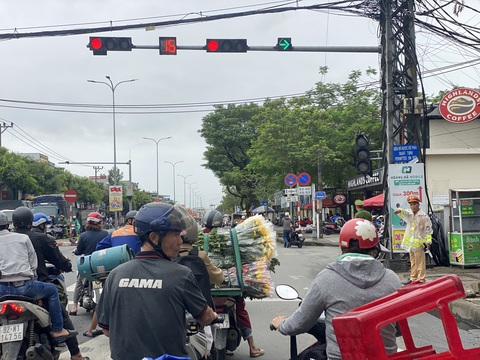 Chuyện lạ ở Đà Nẵng: Đèn đỏ được rẽ phải nhưng rẽ được hay không thì còn... hên xui!- Ảnh 2. Cảnh sát giao thông đứng ở trục Tôn Đức Thắng - Phạm Như Xương để "giành lại" làn rẽ phải cho người đi đường - Ảnh: B.D.