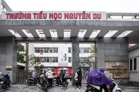 Hà Nội: Nhiều trường cho học sinh nghỉ học vì rét đậm, có trường dạy trực tuyến- Ảnh 1. Cổng Trường tiểu học Nguyễn Du, Hà Nội đầu giờ sáng 23-1. Vẫn có phụ huynh cho con tới trường và các trường vẫn mở cửa đón học sinh - Ảnh: NAM TRẦN