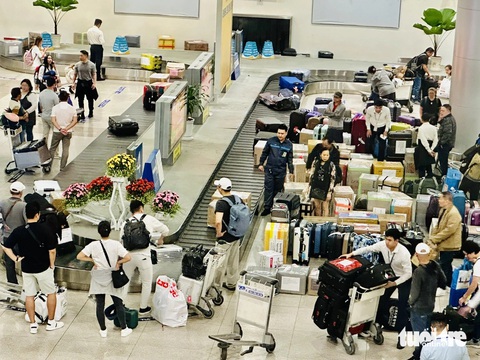 Chộn rộn đón Việt kiều về quê lúc nửa đêm, Tân Sơn Nhất đông đúc người- Ảnh 3. Việt kiều về nước, hành lý rất nhiều. Khách hàng lo ngại chậm trả hành lý dịp Tết khiến nhiều người phải mất công chờ lâu, phiền hà mất cắp hoặc hư hỏng hành lý trong quá trình chuyển lên băng chuyền - Ảnh: CÔNG TRUNG