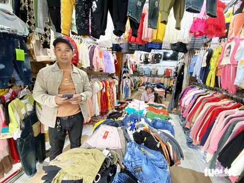 Chợ Tết truyền thống đìu hiu, tiểu thương mỏi mòn đợi khách- Ảnh 5. Cửa hàng bán quần áo của anh Chí ngóng trông khách - Ảnh: LÊ TRUNG