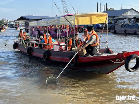 Thanh niên Cần Thơ làm được hơn 5.000 công trình, phần việc trong một năm- Ảnh 1. Hoạt động vớt rác trên chợ nổi Cái Răng của các bạn trẻ Cần Thơ đã tạo được ấn tượng tốt với du khách - Ảnh: LAN NGỌC