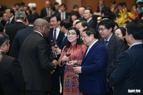 Thủ tướng: Con tàu Việt Nam đã vượt qua sóng cả, vững tay chèo trong năm 2023- Ảnh 3. Thủ tướng Phạm Minh Chính và phu nhân trò chuyện với một nhà ngoại giao nước ngoài tại tiệc chiêu đãi - Ảnh: NAM TRẦN