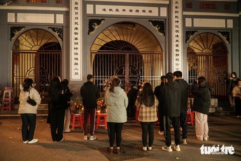 Rằm tháng chạp, người Hà Nội vẫn 'đội' rét 9 độ đi lễ vọng phủ Tây Hồ lúc 0h- Ảnh 1. Nhiều bạn trẻ chia thành từng tốp vái vọng phủ Tây Hồ giữa đêm - Ảnh: PHẠM TUẤN