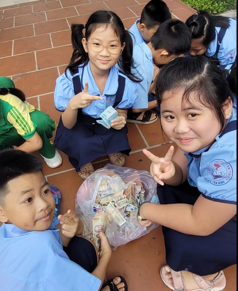 'Cô tặng bạn tiền mua giày mà con ứa nước mắt'- Ảnh 2. Học sinh lớp 1 Trường tiểu học Tân Trụ hào hứng tham gia hội thu heo đất tặng quà Tết cho học sinh nghèo - Ảnh: SONG KHUÊ