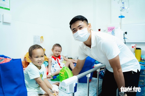 Mắt cha nhòe đi khi con trai ung thư hỏi ngày về ăn Tết- Ảnh 1. Cầu thủ đội bóng TP.HCM Ngô Tùng Quốc cùng đi trao quà cho các bệnh nhi tại Bệnh viện Nhi đồng TP.HCM - Ảnh: THANH HIỆP