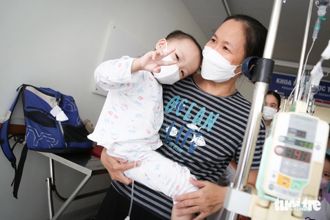 Mắt cha nhòe đi khi con trai ung thư hỏi ngày về ăn Tết- Ảnh 7. Chị Vũ Thị Thanh Nga cùng con gái chờ nhận quà nói: “Tết này không biết có được về quê không nhưng mọi người chia sẻ thế này hai mẹ con vui lắm” - Ảnh: PHƯƠNG QUYÊN