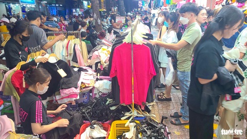 Quần áo, giày dép xả hàng nhiều nơi, chen chân tới nửa đêm ‘săn’ hàng ở TP.HCM- Ảnh 6. 22h khuya, một cửa hàng thời trang trên phố Nguyễn Trãi (quận 5) vẫn sôi động mua bán - Ảnh: NHẬT XUÂN