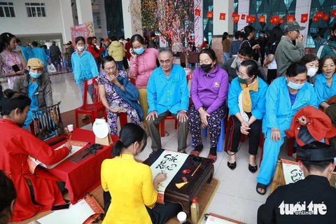 Chụp hình đón Tết để kỷ niệm những ngày mình vẫn còn trên đời- Ảnh 1. Các cô chú bệnh nhân ngồi đợi thầy đồ cho chữ - Ảnh: ĐOÀN NHẠN