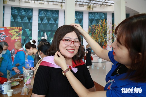 Chụp hình đón Tết để kỷ niệm những ngày mình vẫn còn trên đời- Ảnh 4. Bà Ngô Thị Loan, vừa là người bệnh vừa chăm con gái bệnh nhân K, tươi tắn trong mái tóc giả được các bạn trẻ tặng - Ảnh: ĐOÀN NHẠN