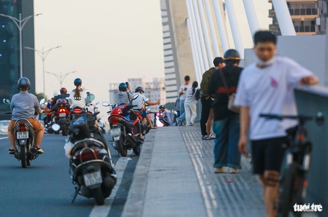 Lao ra giữa dải phân cách cầu Ba Son... tạo dáng chụp hình: Quá nguy hiểm!- Ảnh 5. Không những xe máy mà xe đạp cũng xuất hiện khá nhiều vào mỗi buổi chiều tối. Việc này tiềm ẩn nguy cơ mất an toàn giao thông - Ảnh: CHÂU TUẤN