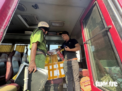 Kiểm tra đột xuất xe dù, cảnh sát giao thông Thủ Đức phát hiện nhiều 'kiểu' vi phạm- Ảnh 3. Một nhà xe chở hàng hóa trong khoang hành khách sai quy định cũng bị lập biên bản xử phạt. Lúc 16h, cảnh sát giao thông đang kiểm tra hàng hóa, giấy tờ xe - Ảnh: THU DUNG
