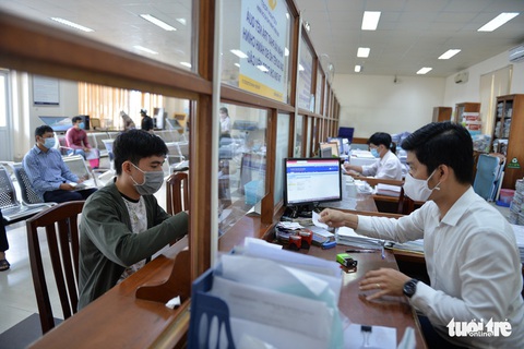 Cải cách thủ tục hành chính, TP.HCM giảm 3.500 giờ làm việc năm 2023- Ảnh 1. Người dân làm thủ tục hành chính một dấu một cửa tại UBND quận 7 (TP.HCM) - Ảnh: TỰ TRUNG