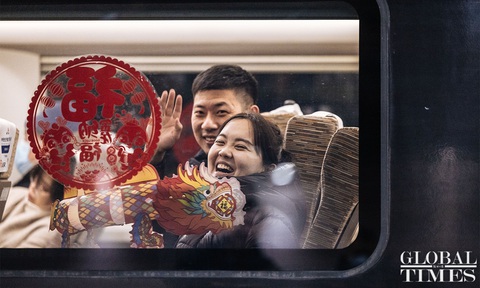 Trung Quốc chính thức bước vào đợt Xuân vận 2024- Ảnh 2. Hai hành khánh vui vẻ vẫy tay với ống kính trước giờ tàu khởi hành - Ảnh: GLOBAL TIMES