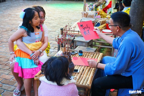 Một ông đồ cho chữ cho du khách - Ảnh: TRẦN HOÀI Một ông đồ tặng chữ cho du khách - Ảnh: TRẦN HOÀI