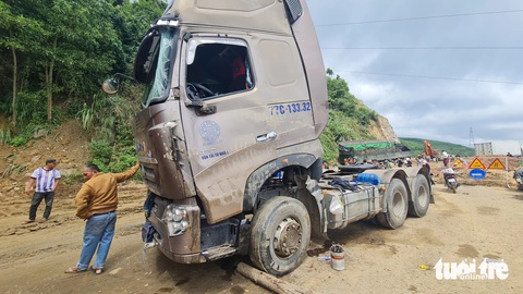 Đầu xe tải bị hư hỏng sau khi bị lật nằm giữa đường khiến các phương tiện qua lại khó khăn - Ảnh: LÂM THIÊN Đầu xe tải bị hư hỏng sau khi bị lật nằm giữa đường, khiến xe cộ qua lại khó khăn - Ảnh: LÂM THIÊN