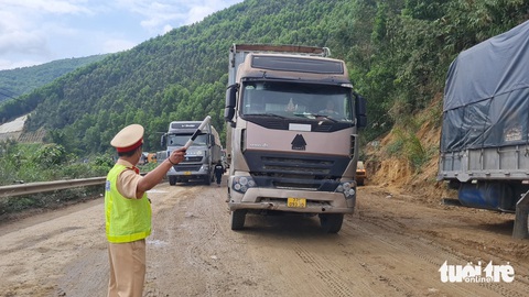 Lực lượng CSGT Công an tỉnh Bình Định điều tiết giao thông đoạn qua hiện trường vụ tai nạn - Ảnh: LÂM THIÊN Lực lượng cảnh sát giao thông Công an tỉnh Bình Định điều tiết giao thông đoạn qua hiện trường vụ tai nạn