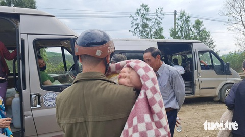 Một em bé ngủ vùi trên vai cha trong lúc chờ đợi thông xe - Ảnh: LÂM THIÊN Một em bé ngủ vùi trên vai cha trong lúc chờ đợi thông xe