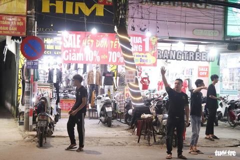 Tết đã gần kề mà 'bán ế chưa từng thấy'- Ảnh 2. Toàn bộ nhân viên của cửa hàng HIM (34 Âu Cơ, quận Liên Chiểu, Đà Nẵng) tràn ra đường mời gọi khách hàng - Ảnh: THANH NGUYÊN