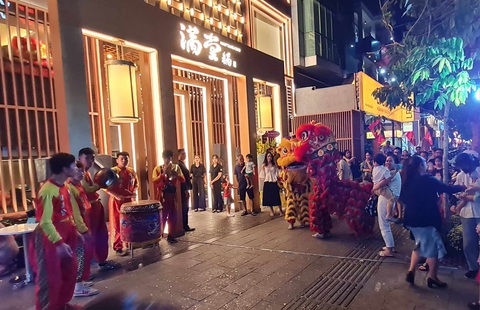 Nếu làm tốt, phố ẩm thực Phan Xích Long sẽ là Hong Kong thu nhỏ- Ảnh 3. Tối 27-1, một nhà hàng tại phố ẩm thực Phan Xích Long tổ chức múa lân để quảng bá, hút thêm thực khách