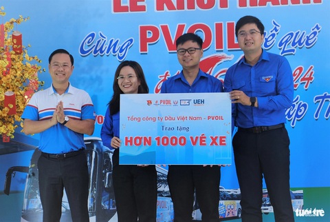 Hơn 1.000 sinh viên TP.HCM về đón Tết cùng chuyến xe miễn phí- Ảnh 2. Anh Mai Xuân Hải, đại diện PVOil, trao bảng tượng trưng số vé xe tặng sinh viên về quê Tết Giáp Thìn 2024 cho đại diện các Đoàn trường - Ảnh: Q.L.
