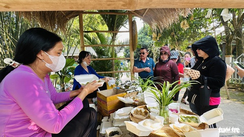 Chợ quê Tân Thuận Đông làm nức lòng du khách- Ảnh 2. Các lại bánh dân gian được du khách ưa chuộng, hộp đựng bánh thân thiện với môi trường - Ảnh: ĐẶNG TUYẾT