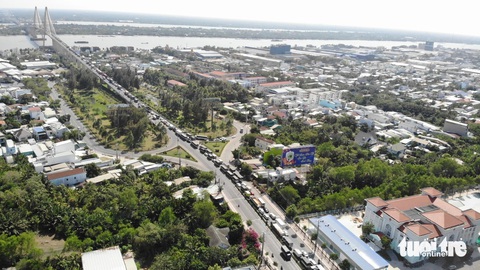 Người dân về quê tảo mộ, cầu Rạch Miễu kẹt xe cứng ngắc- Ảnh 1. Đến 14h30 ngày 20 tháng chạp, dòng xe vẫn xếp hàng kéo dài chờ qua cầu Rạch Miễu.