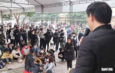 Hàng ngàn người đội mưa rét đăng ký thi đi Hàn Quốc lao động- Ảnh 2. Cán bộ Trung tâm Giới thiệu việc làm tỉnh Nghệ An dùng loa đọc số thứ tự cho người dân vào làm thủ tục - Ảnh: DOÃN HÒA