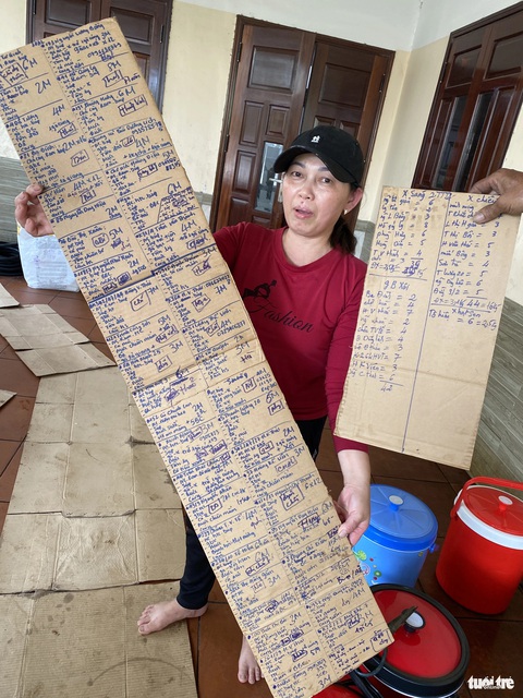 Làng ‘nấu tiệc’ cuối năm, những tờ đơn đặt hàng dài cả mét- Ảnh 4. Đơn đặt tiệc của khách dài như tờ sớ tại cơ sở của vợ chồng ông Thông - Ảnh: B.D.