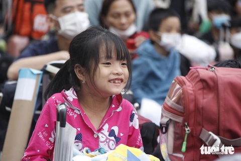 2.200 sinh viên, người lao động về Tết trên Chuyến xe mùa xuân- Ảnh 4. Một bạn nhỏ vui mừng vì sắp được về quê đón Tết cùng ông bà - Ảnh: CÔNG TRIỆU