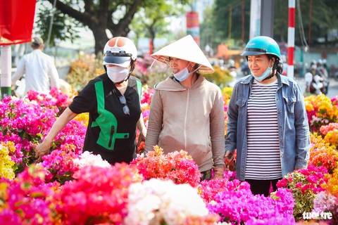 Thuyền hoa cập Bến Bình Đông, người dân tranh thủ sắm Tết sớm- Ảnh 6. Chậu hoa giấy nhỏ với giá từ 100.000 đồng thu hút sự quan tâm của nhiều khách hàng - Ảnh: PHƯƠNG QUYÊN