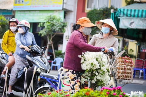 Thuyền hoa cập Bến Bình Đông, người dân tranh thủ sắm Tết sớm- Ảnh 7. Cô Lan (quận 8) chọn được chậu hoa giấy trắng bung đều ưng ý - Ảnh: PHƯƠNG QUYÊN