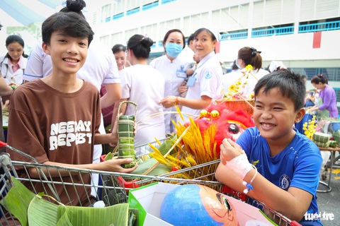 Bác sĩ, y tá, bệnh nhi gói bánh tét vui Tết sớm- Ảnh 3. Lần đầu tham gia thi gói bánh tại nơi đặc biệt như bệnh viện, đôi bạn Tiến và Đạt đều hào hứng