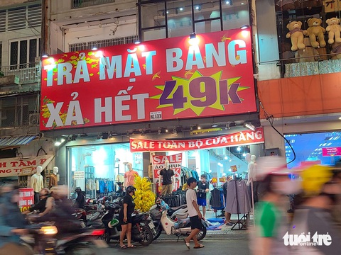 Cửa hàng thời trang 'lay lắt' đợi khách tới khuya- Ảnh 3. Một cửa hàng quần áo trên đường Nguyễn Trãi (quận 5) treo biển lớn "xả kho trả mặt bằng" giữa mùa mua sắm cao điểm - Ảnh: NHẬT XUÂN