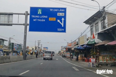 Chật vật tìm đường vào cao tốc Mỹ Thuận - Cần Thơ về miền Tây- Ảnh 1. Biển báo tại nút giao thông An Thái Trung (huyện Cái Bè, tỉnh Tiền Giang) khiến nhiều tài xế nhầm lẫn đây là biển hướng dẫn tài xế đi vào nút giao để qua cầu Mỹ Thuận 2 - Ảnh: MẬU TRƯỜNG