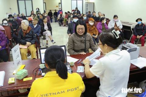 Cô Nguyễn Thị Quế (áo xám) phấn khởi khi nhận lương hưu hai tháng liền - Ảnh: HÀ QUÂN Cô Nguyễn Thị Quế (giữa) phấn khởi khi nhận lương hưu hai tháng liền - Ảnh: HÀ QUÂN