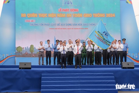 Xử lý nồng độ cồn là giải pháp nổi bật đảm bảo an toàn giao thông năm 2023- Ảnh 1. Phó chủ tịch UBND TP.HCM Bùi Xuân Cường thực hiện nghi thức trao cờ lệnh cho phó trưởng ban chuyên trách Ban An toàn giao thông TP.HCM Nguyễn Thành Lợi - Ảnh: PHƯƠNG NHI