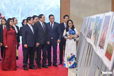 Thủ tướng Việt Nam, Lào gặp nhau lần thứ 7 trong chưa đầy 1 năm- Ảnh 4. Thủ tướng Phạm Minh Chính và phu nhân cùng Thủ tướng Lào Sonexay Siphandone và phu nhân xem triển lãm ảnh về quan hệ hai nước - Ảnh: NGUYỄN KHÁNH