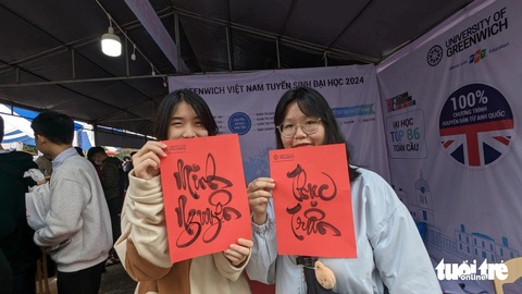 Tư vấn tuyển sinh tại Huế: Học sinh hào hứng tìm hiểu ngành nghề- Ảnh 4. Hai bạn trẻ được ông đồ của Trường đại học Greenwich tặng chữ - Ảnh: NHẬT LINH